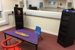 A room with a table, chairs and testing equipment