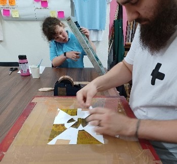 Image shows artists working on lino cutting projects.