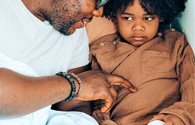 A man and boy sit together talking