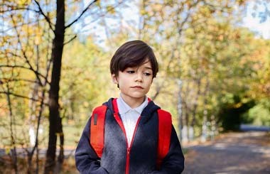 A boy walking outside on his own