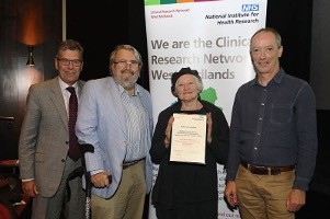 Three men and a woman holding a certificate