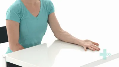 Moving image of someone sat with their hand on a table, turning their hand over