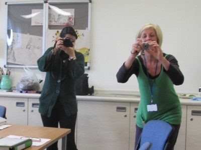 Image shows two women holding cameras.