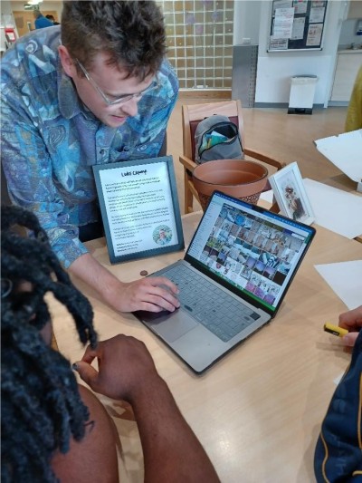 Artist working with service users using a laptop