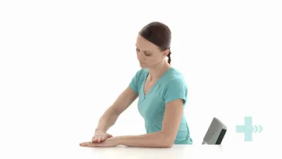 moving image of someone sat with their hand on a table, lifting one hand and pushing it back down with the other