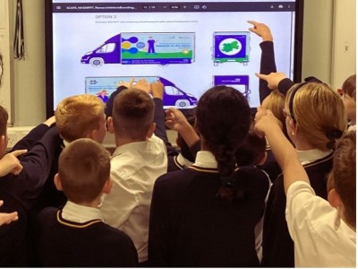 Primary school children looking at a research bus graphic